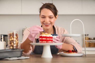 Mutfakta pastayı süsleyen kadın pastacı.