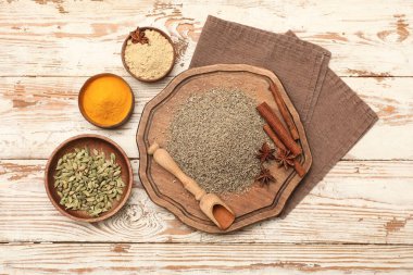 Baharatlı kase ve yemek, bej ahşap arka planda kepçe.