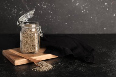 Kurumuş anason tohumları ve siyah grunge arka planda kaşık dolu ahşap tahta bir kutu.