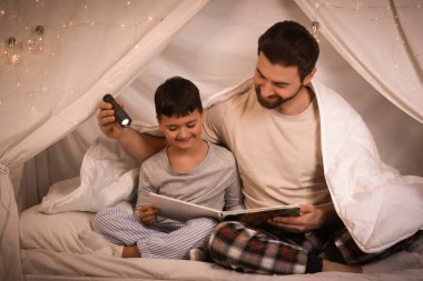 El fenerli baba ve küçük oğlu kulübede masal okuyorlar.