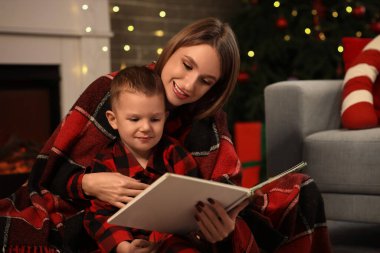Anne ve küçük oğlu Noel arifesinde evde masal okuyorlar.