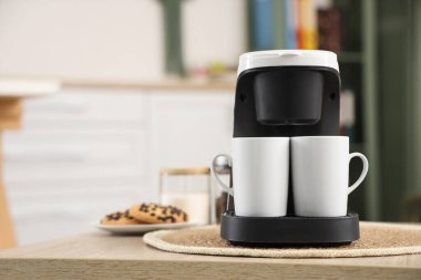 Ofisteki masada fincanlı kahve makinesi, yakın plan.