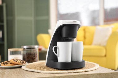 Kahve makinesi, masada fincanlar, yakın plan.