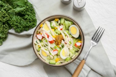 Yengeç çubuklu salata, mısır, buzdağı yaprağı, bıldırcın yumurtası ve beyaz arka planda salatalık.