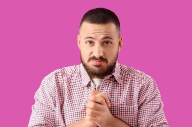 Mor arka planda özür dileyen genç adam, yakın plan.