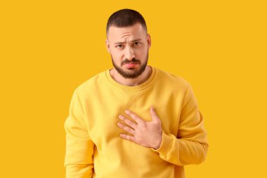 Apologetic young man on yellow background clipart