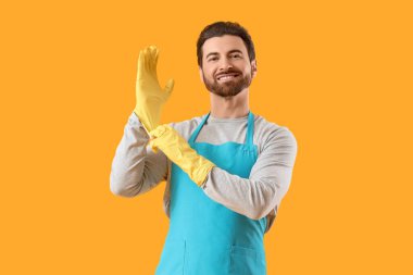 Erkek hademe sarı arka plana lastik eldiven takıyor.