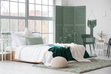 Konforlu yatak odası ve katlanabilir perdesi olan modern yatak odası.