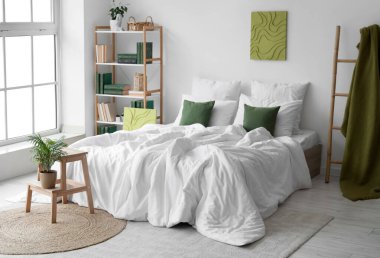 Yatak odasının iç tarafında yeşil ekoseli rahat yatak, kitaplık ve merdiven.