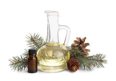 Beyaz zemin üzerinde çam kozalakları olan bir şişe ve bir sürahi gerekli yağ.
