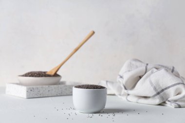 Beyaz arkaplanda chia tohumları olan kaseler
