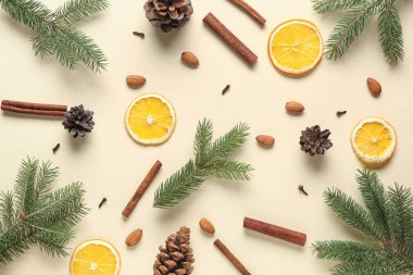 Köknar dalları, baharatlar, kurutulmuş portakal dilimleri ve renk arkaplanda çam kozalakları ile kompozisyon
