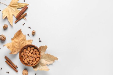 Gri arka planda badem fıstığı, baharat, meşe palamudu ve düşen yapraklı kompozisyon