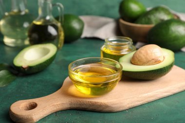 Yeşil arka planda bir kase avokado yağı.