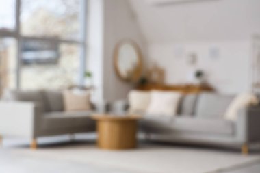 Gri kanepeleri ve masaları olan bulanık oturma odası manzarası