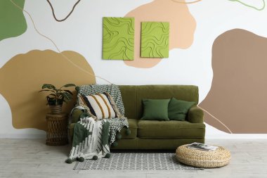 Rahat bir kanepe, dergi ve odanın renkli duvarlarında resimler.