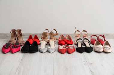 Aydınlık duvarın yanında farklı kadın ayakkabıları.