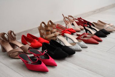 Aydınlık duvarın yanında farklı kadın ayakkabıları.