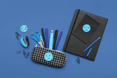 Mavi arka planda üzgün yüzler çizilmiş ofis kırtasiyesi