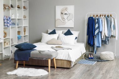 Modern yatak odasında farklı kıyafetler ve aksesuarlarla dolu bir gardırop.