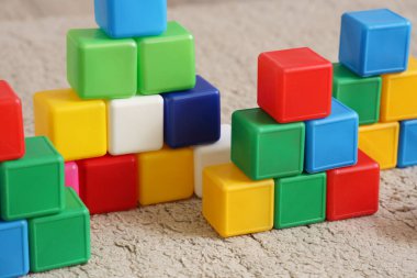 Çocuk odasında halının üzerinde renkli küpler, yakın plan.