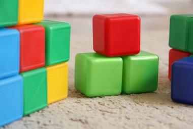 Çocuk odasında halının üzerinde renkli küpler, yakın plan.