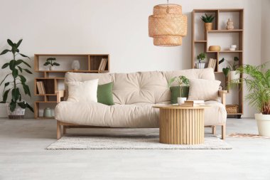 Oturma odasının içinde kanepe, kahve masası ve bitkiler var.