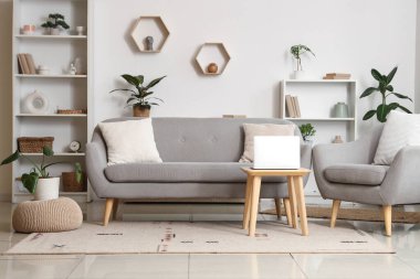 Oturma odasının içinde kanepe, sehpa ve koltuk var.