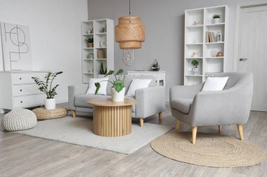 Oturma odasının içinde kanepe, sehpa ve raf üniteleri var.