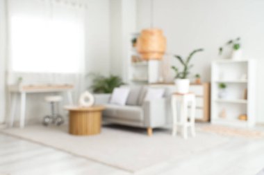 Gri kanepeli, masalı ve raf üniteli oturma odasının bulanık görüntüsü