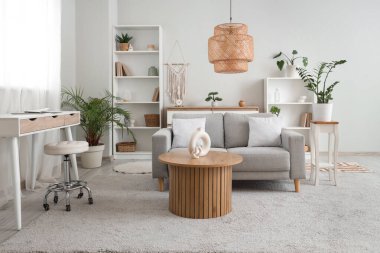 Gri kanepeli, masalı ve raf üniteli oturma odasının içi.