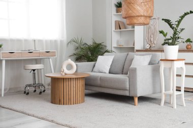 Gri kanepeli, masalı ve raf üniteli oturma odasının içi.