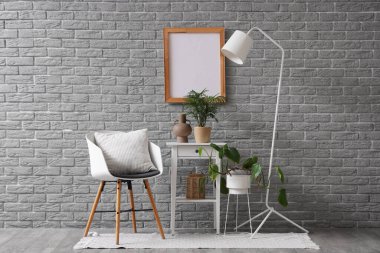 Oturma odasının içinde koltuk, masa ve lamba var.