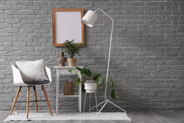 Oturma odasının içinde koltuk, masa ve lamba var.