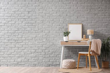 Gri tuğla duvarın yanındaki boş çerçeveli işyeri