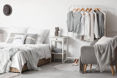 Giysilerle, koltukla ve yatak odasının iç kısmında rahat bir yatak.