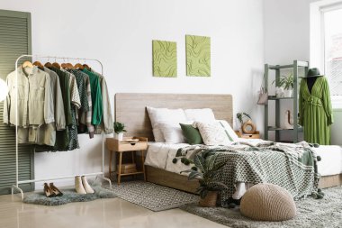 Modern yatak odasının içinde giysi ve mankenlerle dolu raflar.