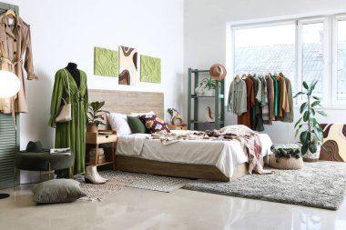 Elbise askılığı ve mankeni olan şık bir yatak odası.