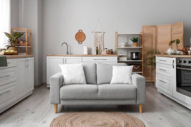 Mutfağın içinde tezgah, raf üniteleri ve kanepe var.