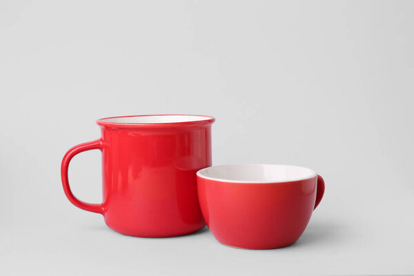 Красные керамические чашки на сером фоне
