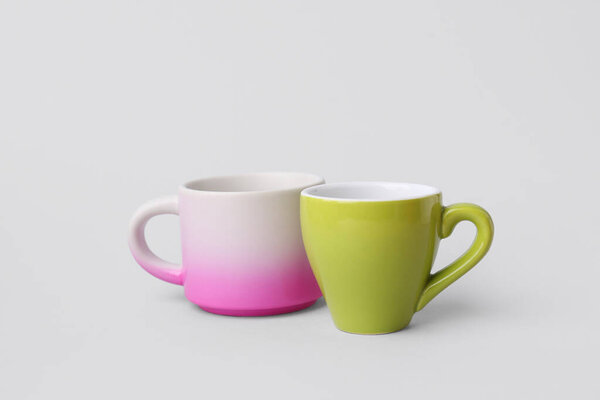 Различные керамические чашки на сером фоне