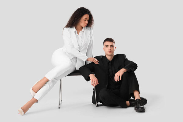 Young couple sitting on white background. Yin Yang concept