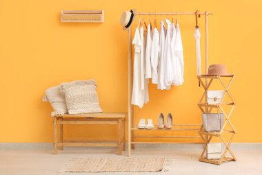 Elbise askısı, durağı ve bankı olan şık bir koridor.