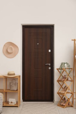 Kapı, ayakkabı standı ve raf ünitesi olan ışık koridorunun içi.