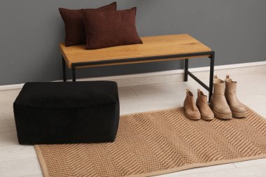 Yastıklı bank, botlar ve pouf koridorda.