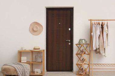 Elbise askısı, ayakkabı standı ve kapısı olan ışık koridorunun içi.