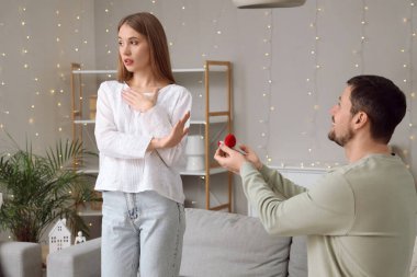 Evdeki erkek arkadaşının evlilik teklifini reddeden genç bir kadın.