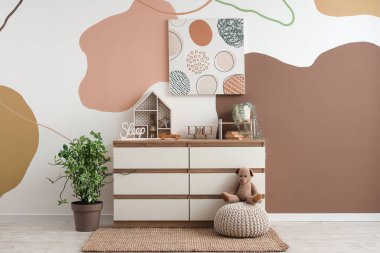 Tuvalet, resim ve oyuncaklarla dolu bir kreş.