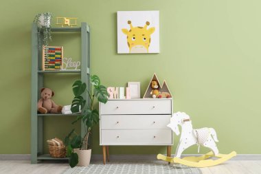 Tuvaleti, raf ünitesi ve oyuncakları olan bir kreş.