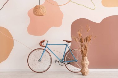 Renk duvarına yakın otlu modern bisiklet ve vazo